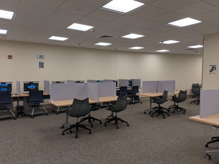The OAS Testing Center has a variety of seating types with dividers between many of the seats. 